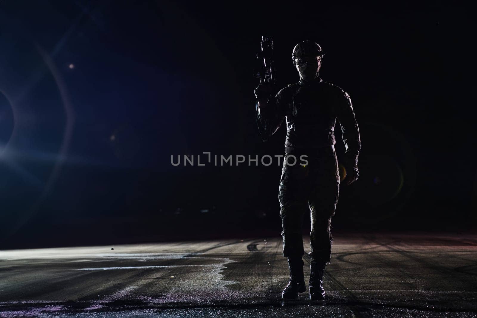 A professional soldier in full military gear striding through the dark night as he embarks on a perilous military mission.