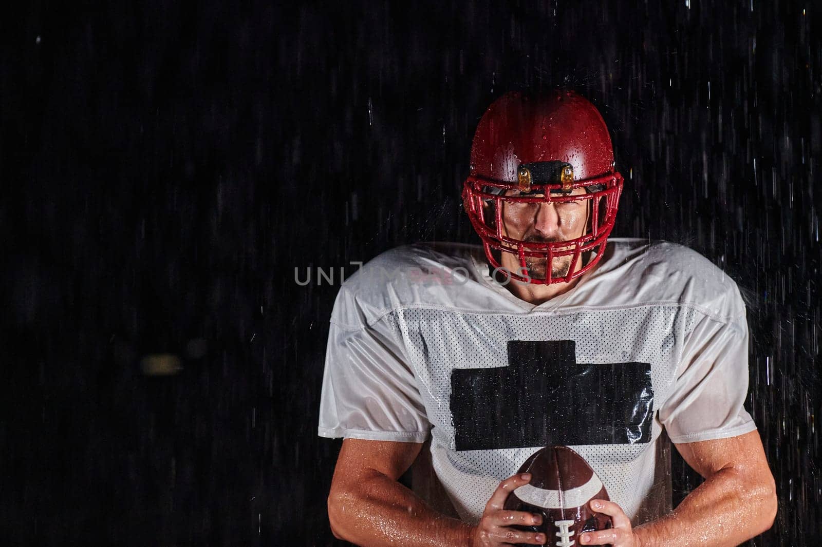 American Football Field: Lonely Athlete Warrior Standing on a Field Holds his Helmet and Ready to Play. Player Preparing to Run, Attack and Score Touchdown