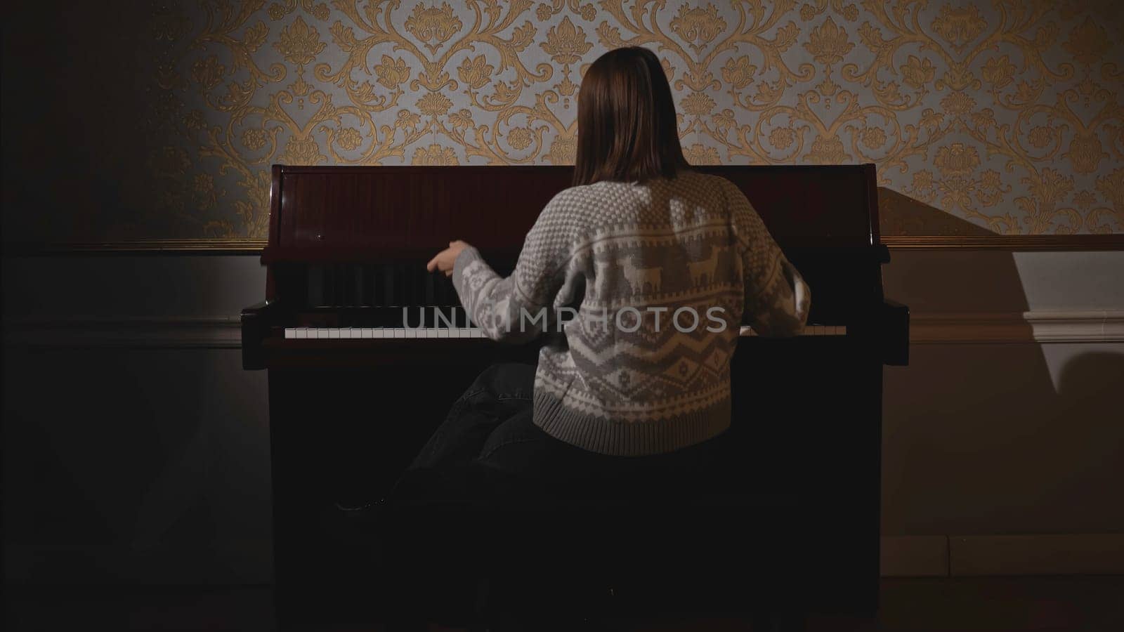 Woman closes piano. Media. Sad woman closes lid of old piano and leaves. Sad memories of old house and piano.