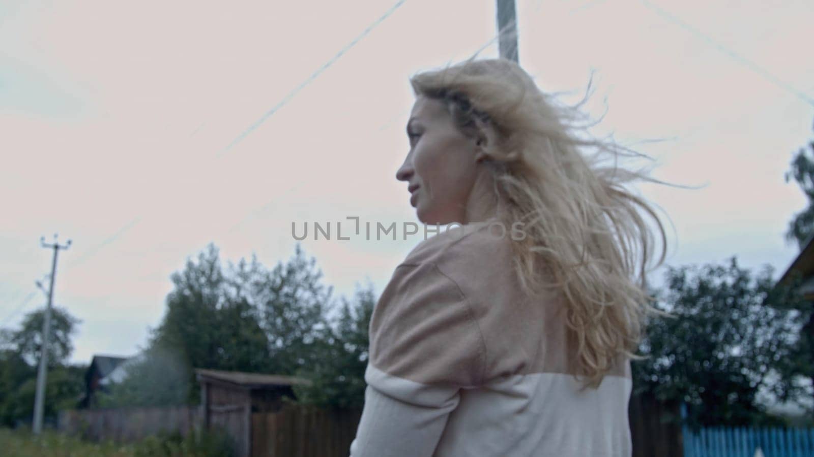 Woman standing in cabriolet car on summer village background. Stock. Couple in a car in the countryside