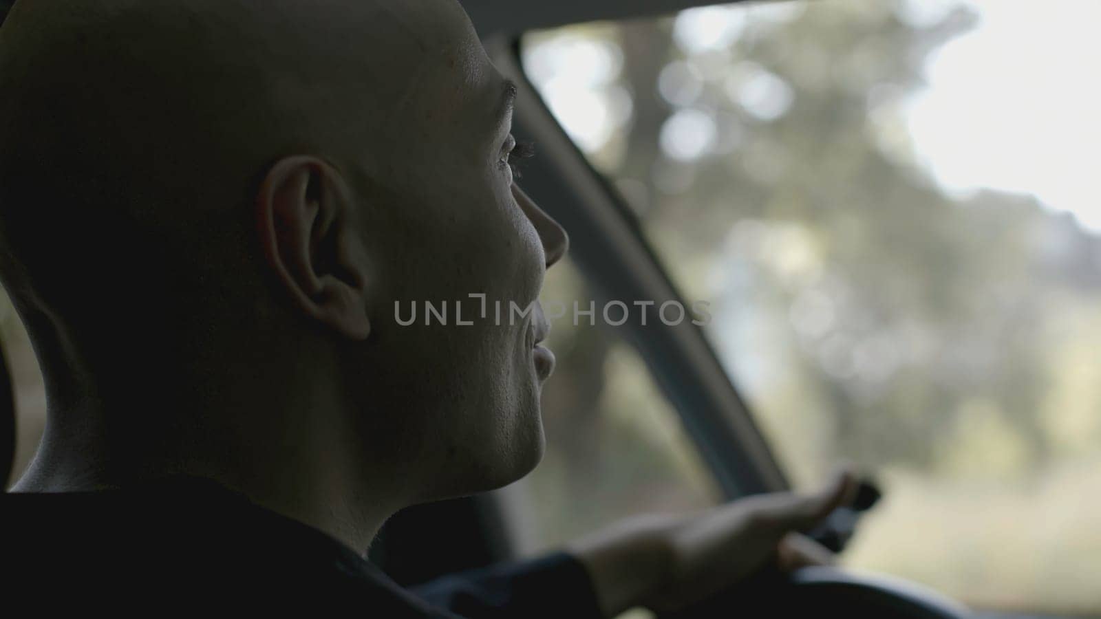 Rear view of talking taxi driver. Stock. View from passenger seat to taxi driver. Cinematic view of talking friendly car driver.