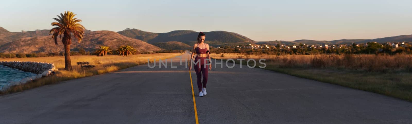 Healthy young couple jogging in the city streets in the early morning with a beautiful sunrise in the background.