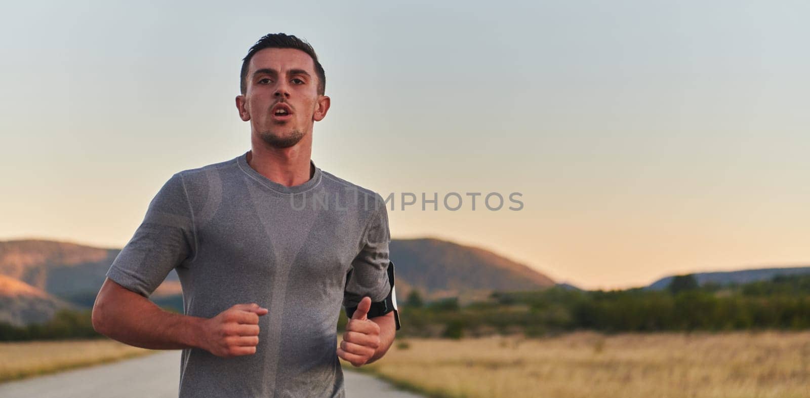 A young handsome man running in the early morning hours, driven by his commitment to health and fitness by dotshock