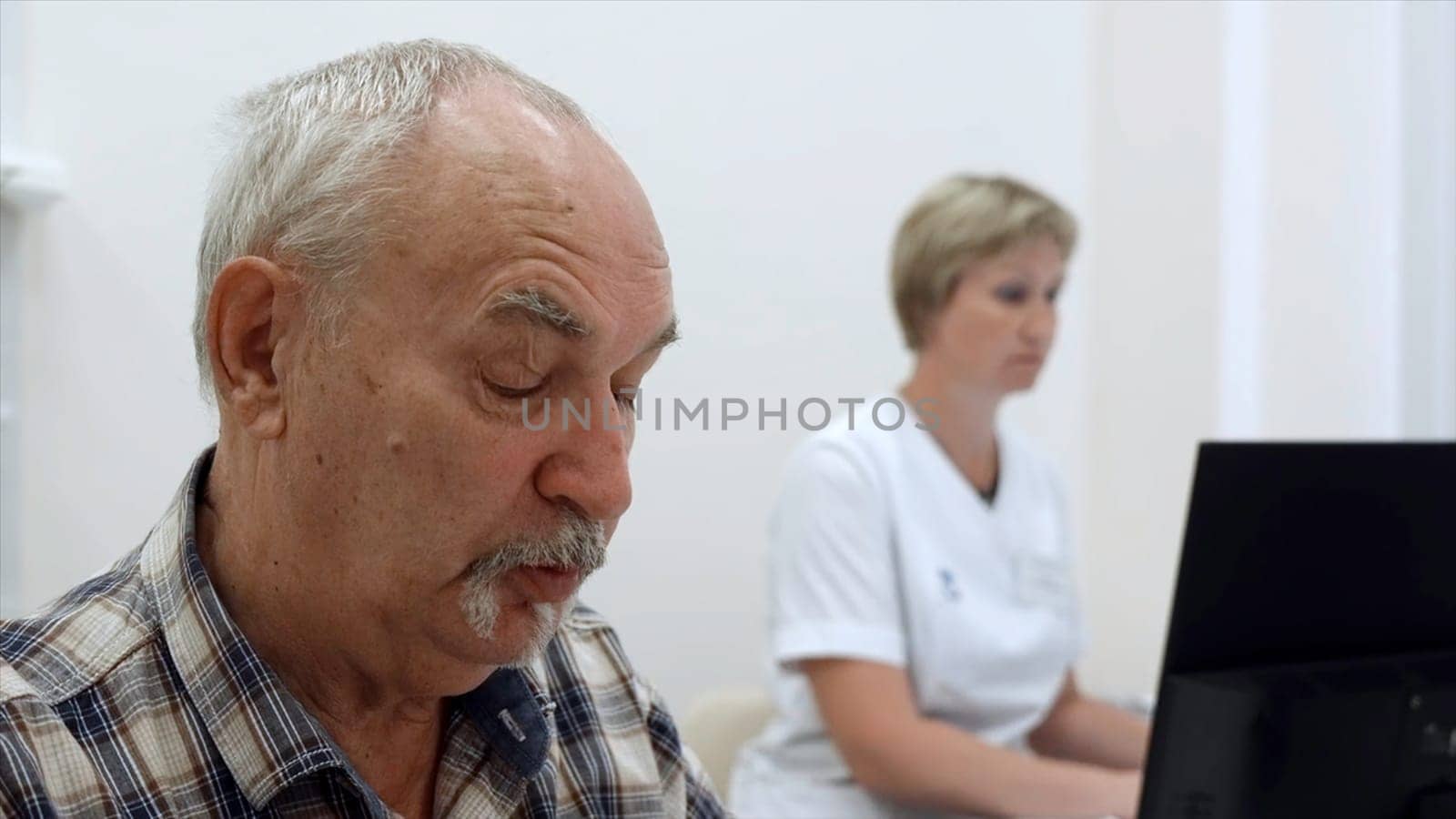 Portrait of an old man patient talking to doctor with female nurse behind. Clip. Concept of public health services