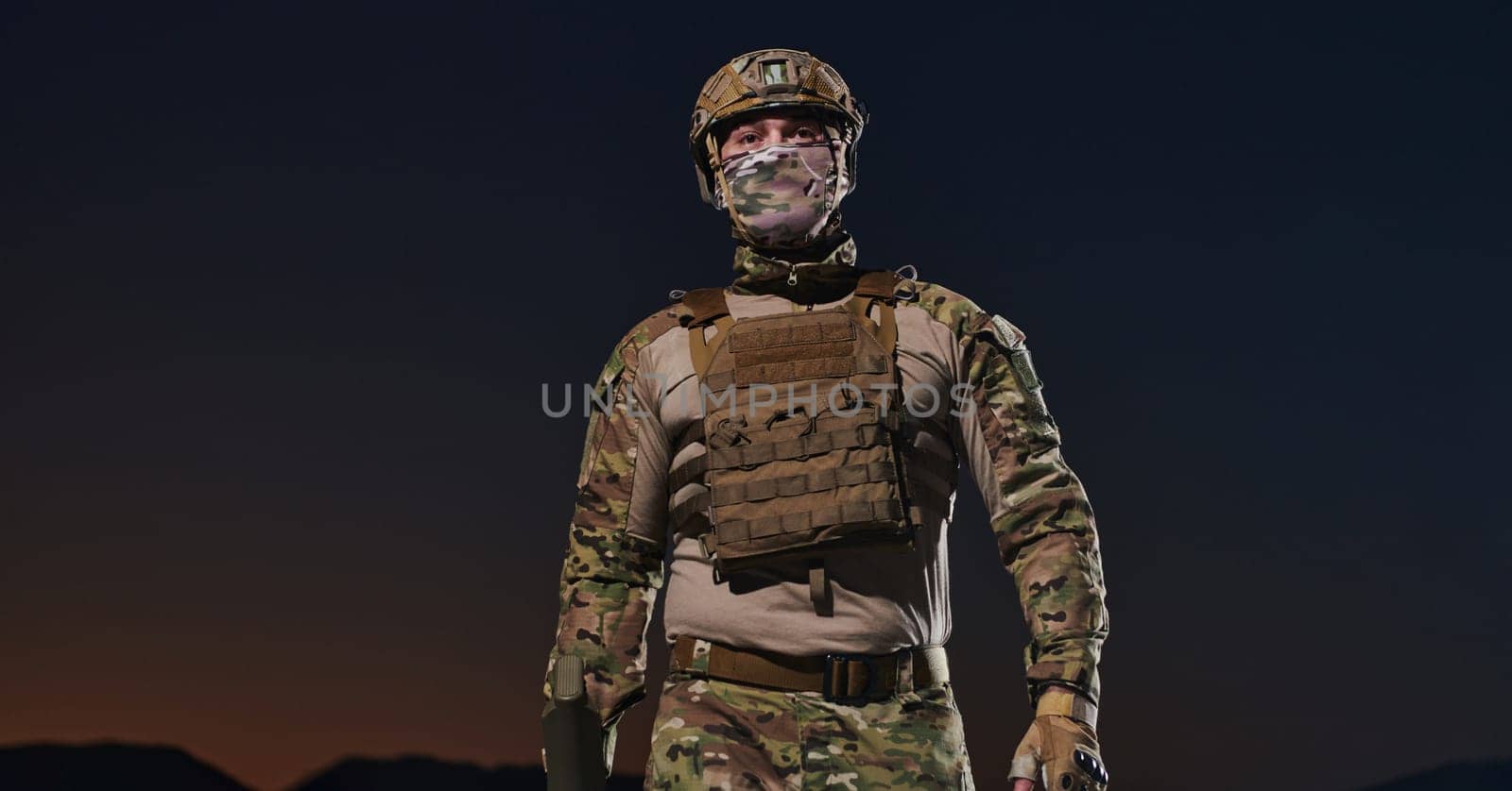 A professional soldier in full military gear striding through the dark night as he embarks on a perilous military mission.