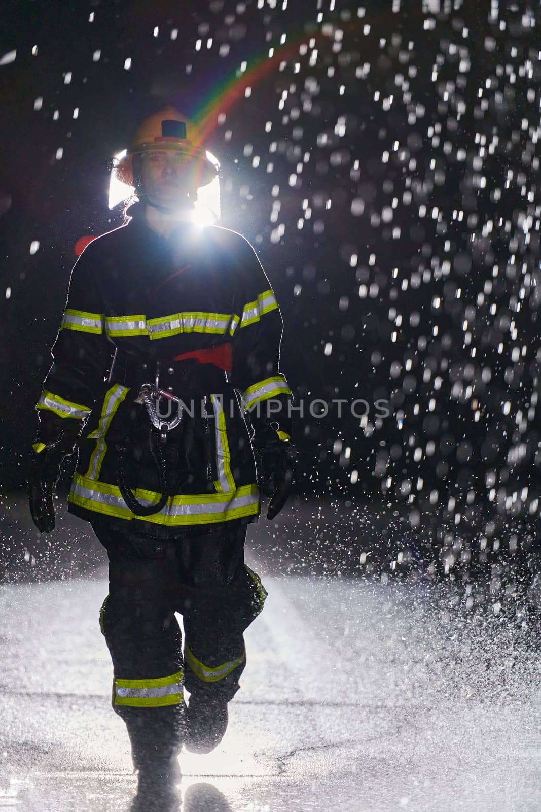 A determined female firefighter in a professional uniform striding through the dangerous, rainy night on a daring rescue mission, showcasing her unwavering bravery and commitment to saving lives. by dotshock