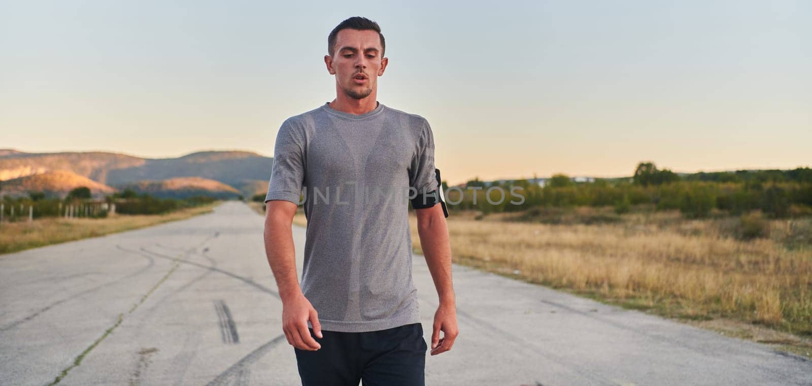 A young handsome man running in the early morning hours, driven by his commitment to health and fitness by dotshock