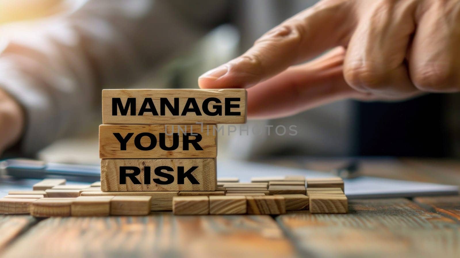 Person's Hand Stacking Wooden Blocks with Manage Your Risk Inscribed Concept Financial and Business Risk Management.