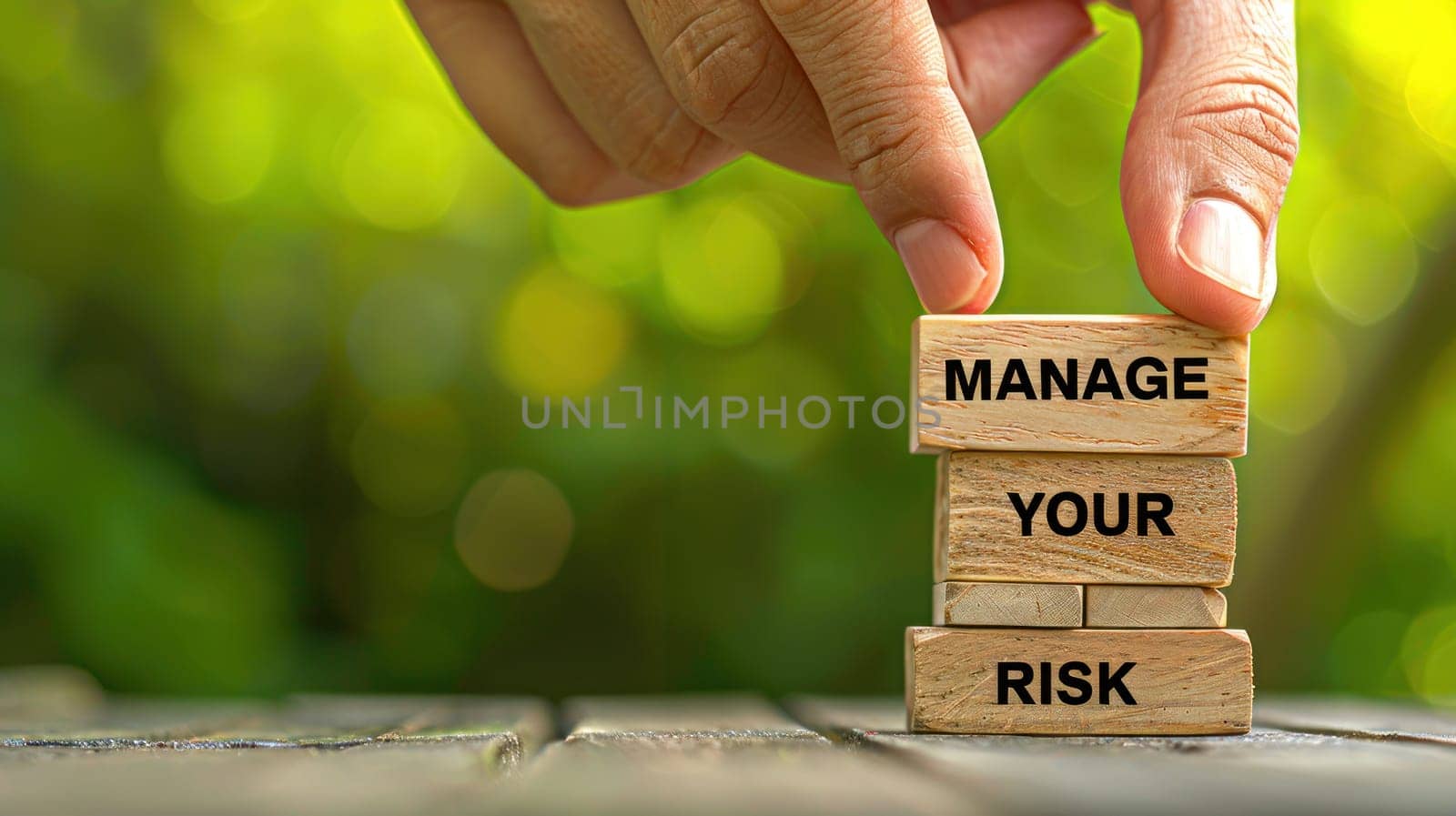 Person's Hand Stacking Wooden Blocks with Manage Your Risk Inscribed Concept Financial and Business Risk Management.