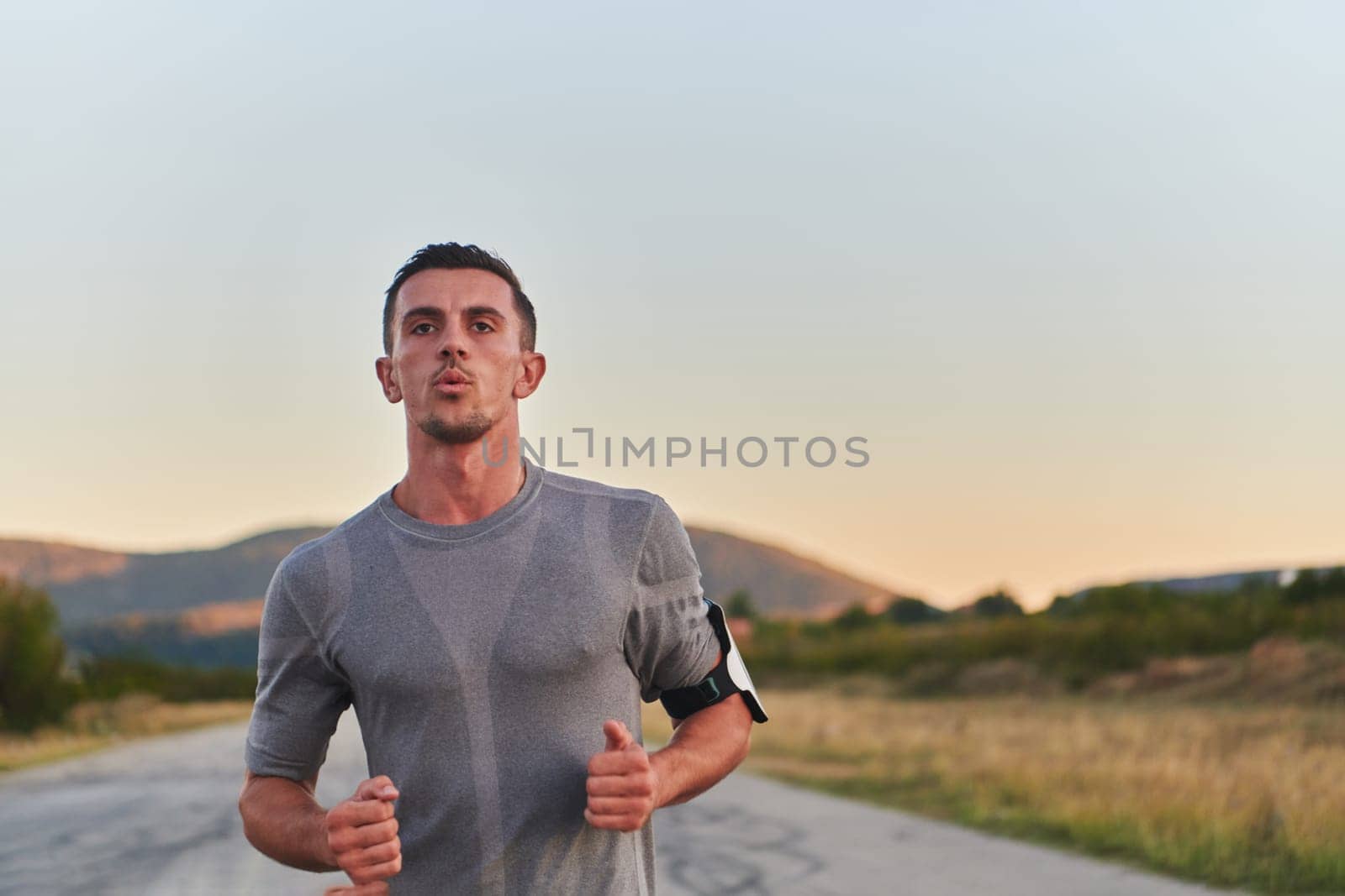 A young handsome man running in the early morning hours, driven by his commitment to health and fitness by dotshock