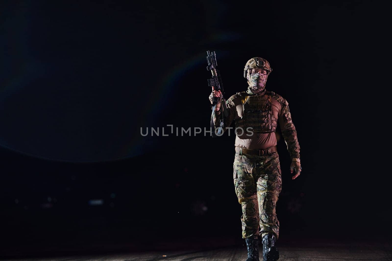 A professional soldier in full military gear striding through the dark night as he embarks on a perilous military mission.