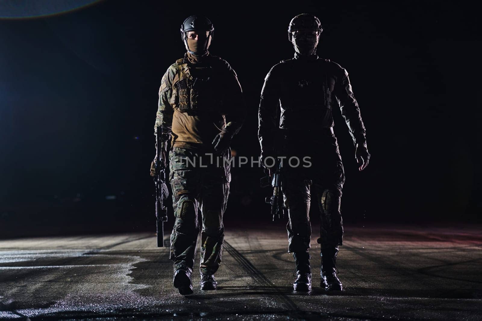 Two professional soldiers marching through the dark of night on a dangerous mission, epitomizing their unwavering bravery, unwavering teamwork, and the high-stakes intensity of their specialized training as they prepare to confront unknown perils in the name of duty and sacrifice