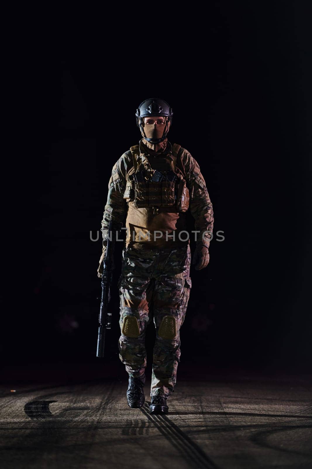 A professional soldier in full military gear striding through the dark night as he embarks on a perilous military mission by dotshock