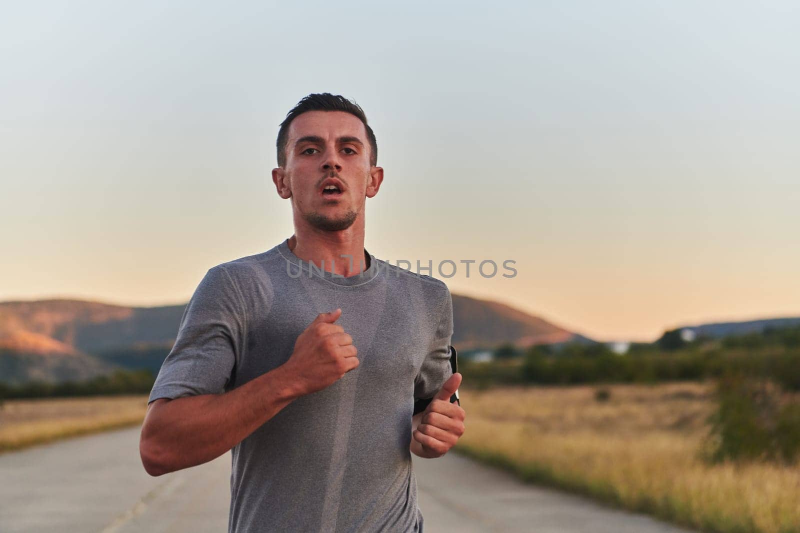 A young handsome man running in the early morning hours, driven by his commitment to health and fitness by dotshock