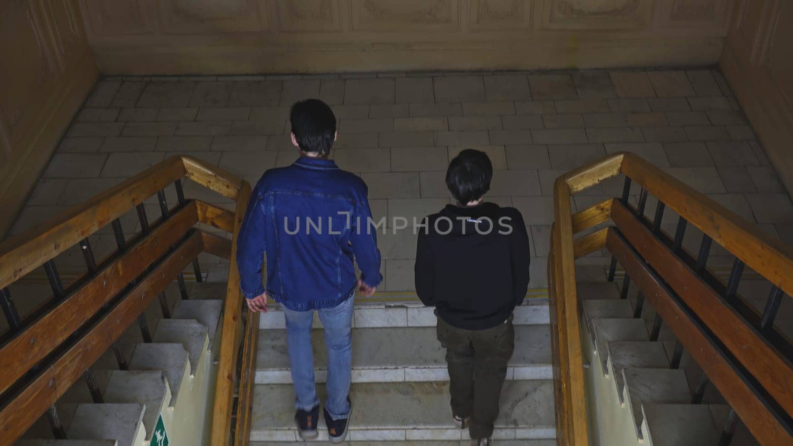 Students walk up stairs of building. Media. Students climb stairs of university. Students inside university walk up stairs by Mediawhalestock