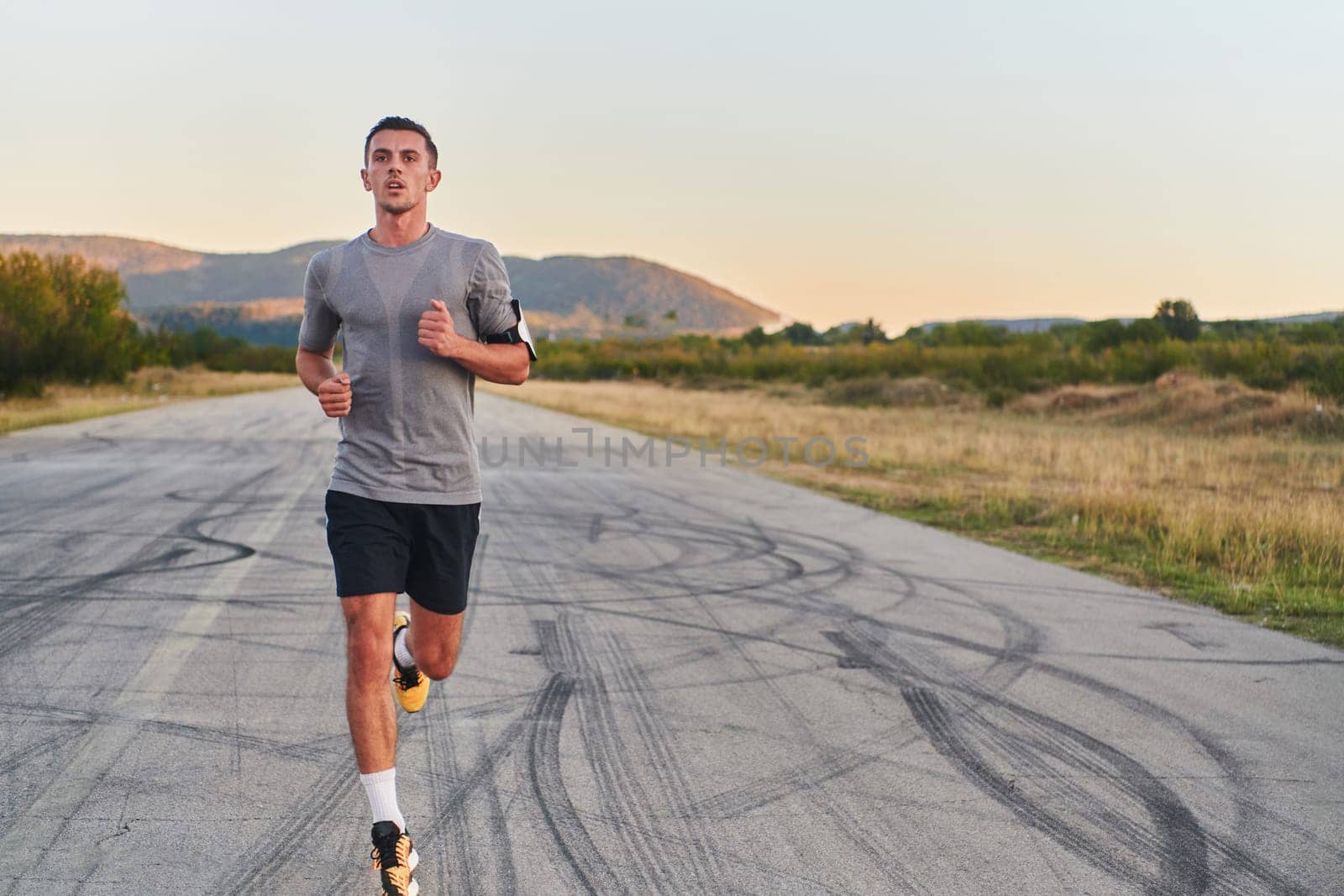 A young handsome man running in the early morning hours, driven by his commitment to health and fitness by dotshock