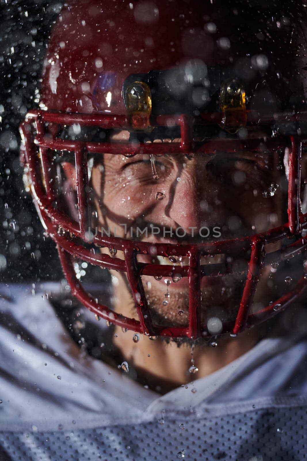 American Football Field: Lonely Athlete Warrior Standing on a Field Holds his Helmet and Ready to Play. Player Preparing to Run, Attack and Score Touchdown. Rainy Night with Dramatic Fog, Blue Light.