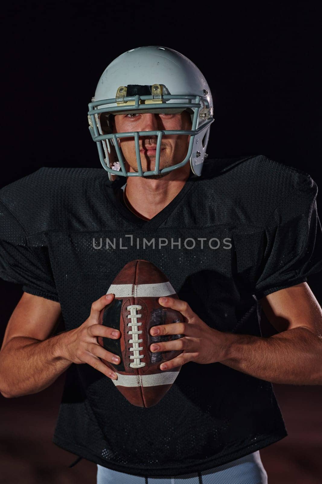 American Football Field: Lonely Athlete Warrior Standing on a Field Holds his Helmet and Ready to Play. Player Preparing to Run, Attack and Score Touchdown