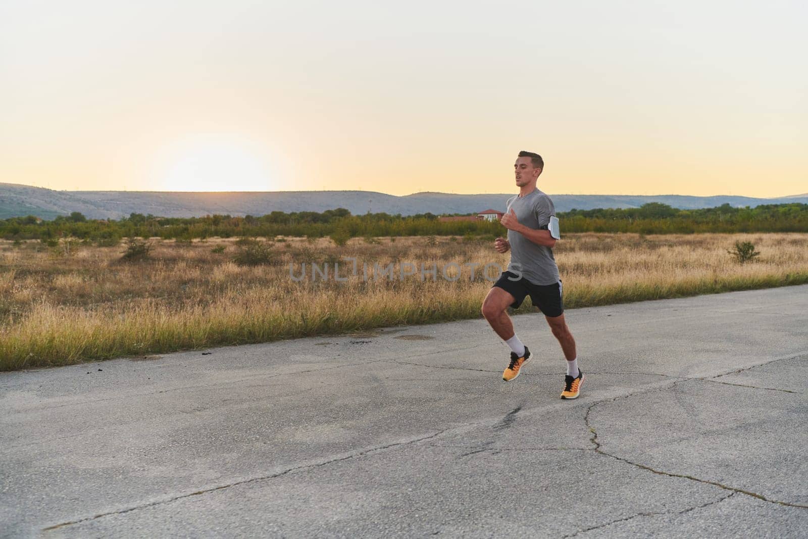 A young handsome man running in the early morning hours, driven by his commitment to health and fitness by dotshock