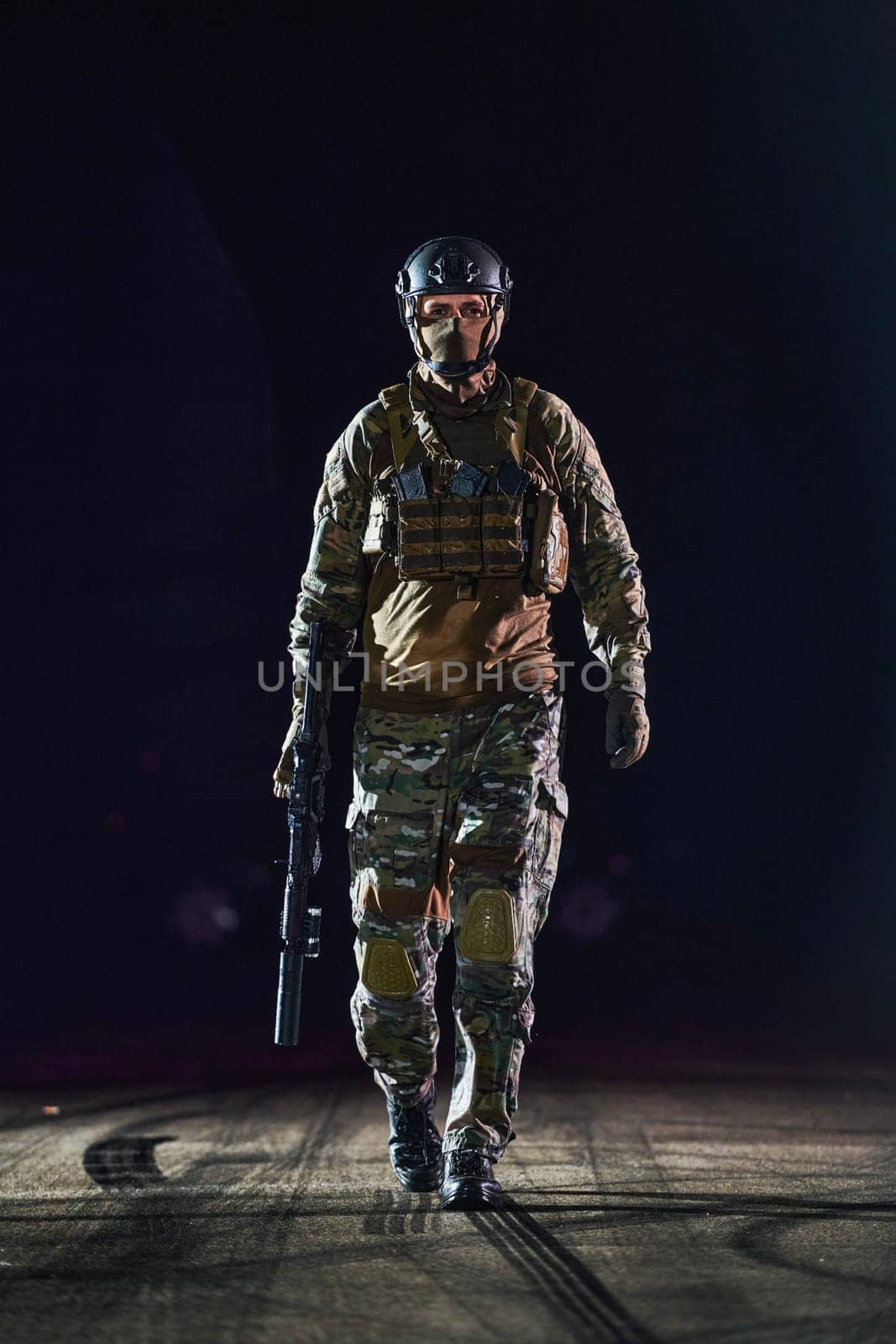 A professional soldier in full military gear striding through the dark night as he embarks on a perilous military mission by dotshock