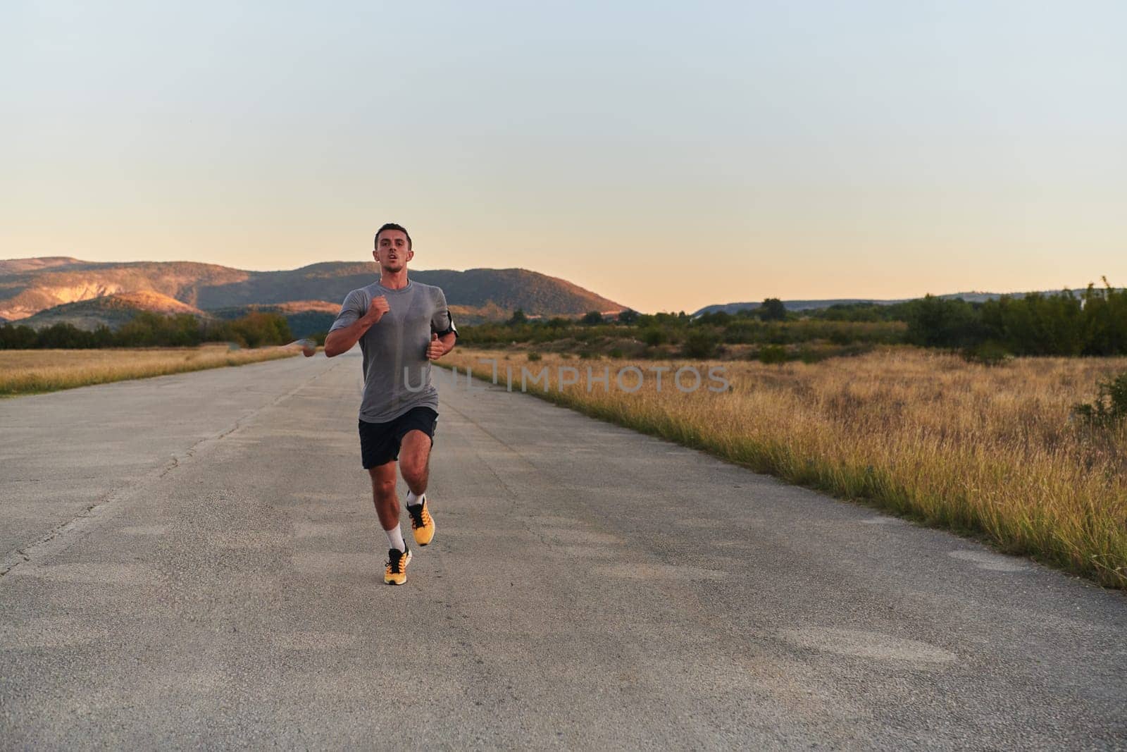 A young handsome man running in the early morning hours, driven by his commitment to health and fitness by dotshock