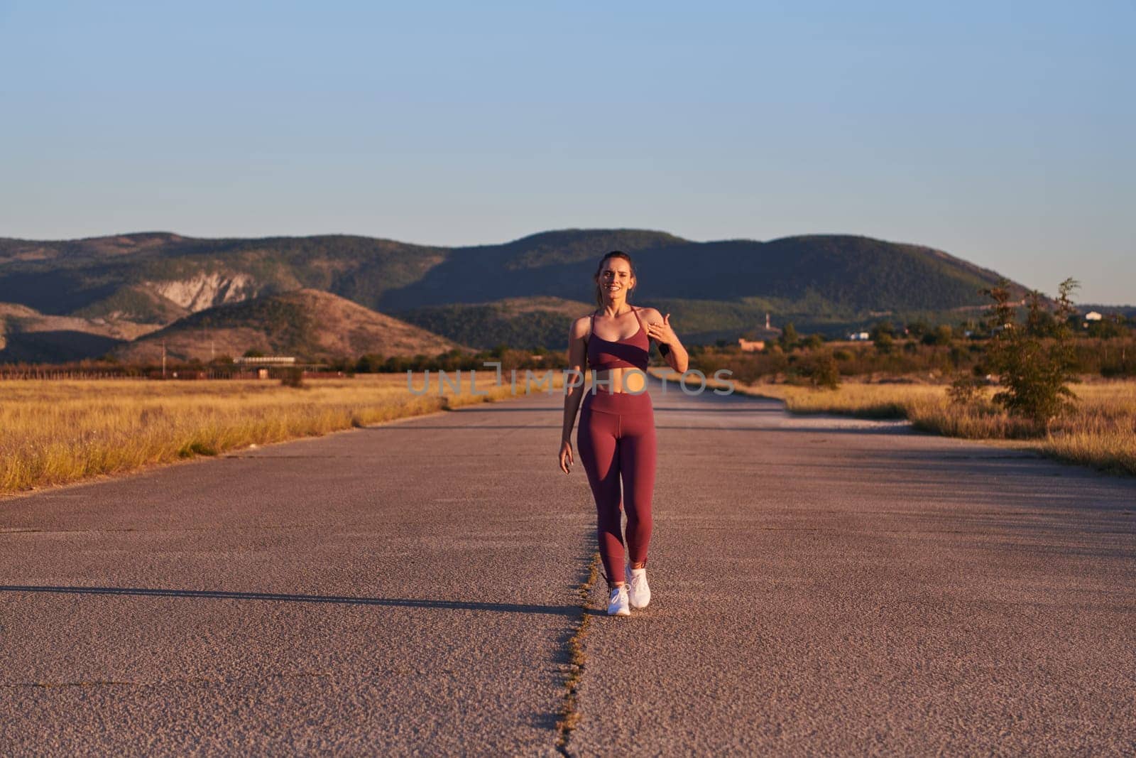 Healthy young couple jogging in the city streets in the early morning with a beautiful sunrise in the background by dotshock