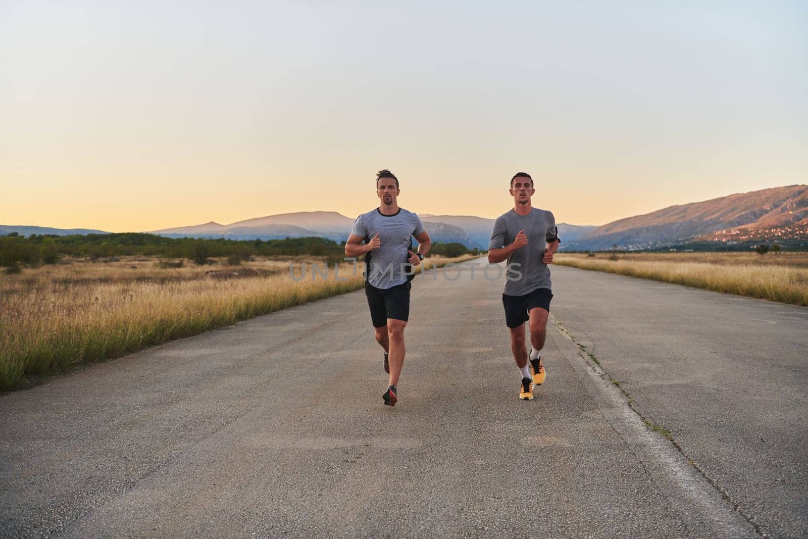 Group of handsome men running together in the early morning glow of the sunrise, embodying the essence of fitness, vitality, and the invigorating joy of embracing nature's tranquility during their refreshing and energizing workout