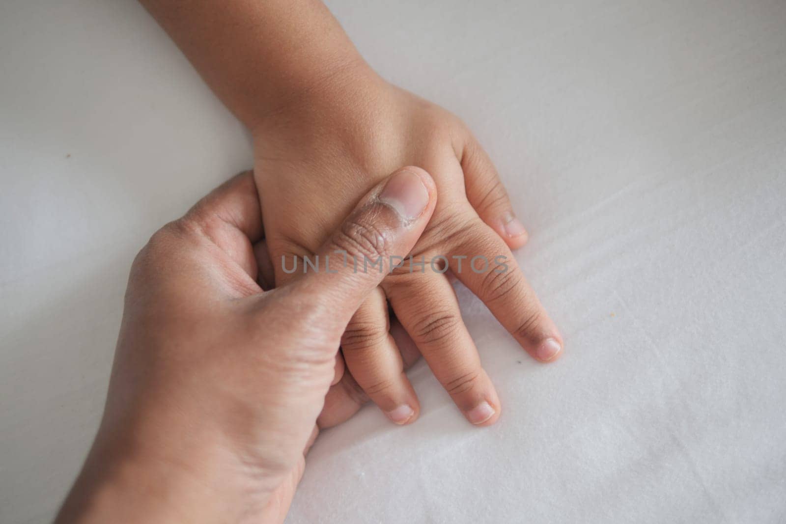 father holding hand of baby child, close up