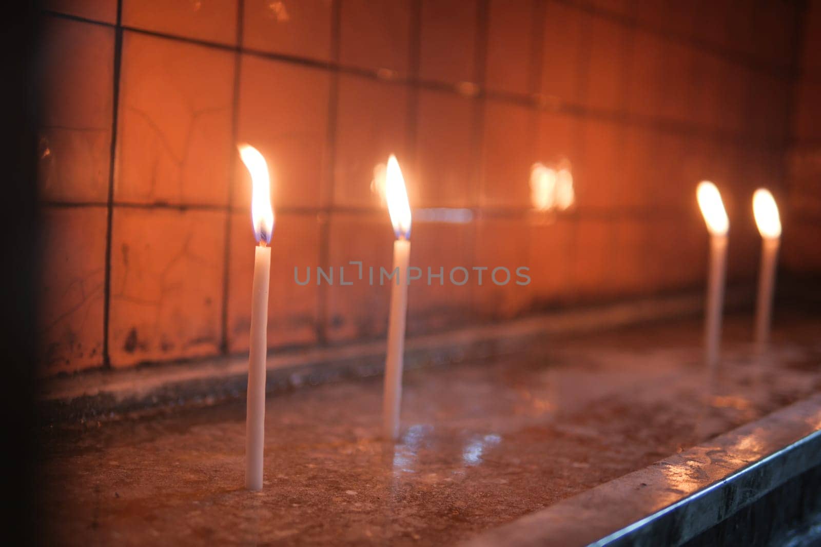 Row of burning candles in a church