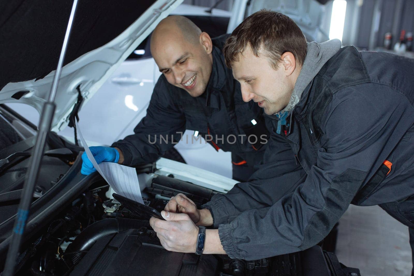 mechanic men with wrench repairing car at workshop