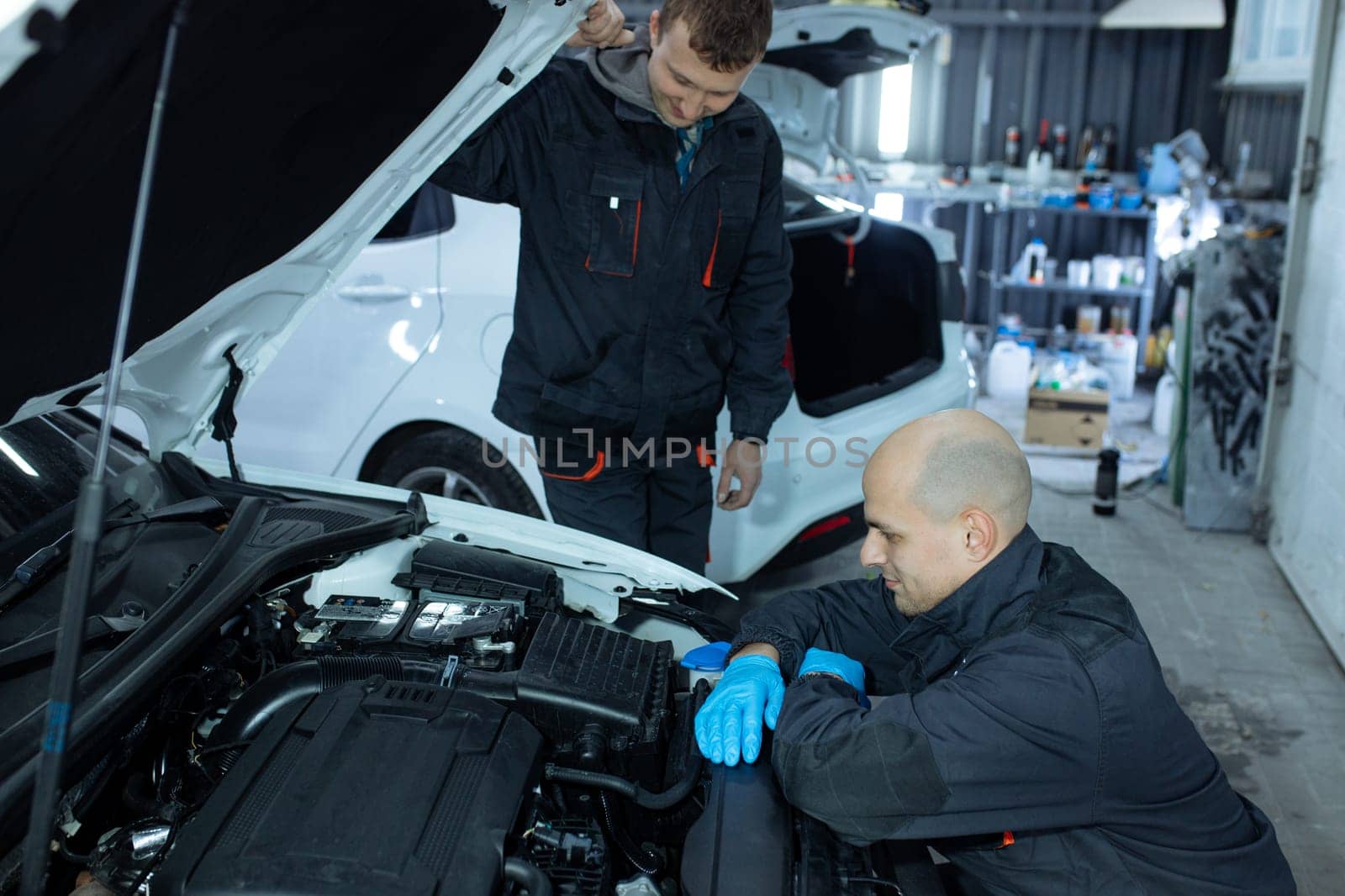 mechanic men with wrench repairing car at workshop