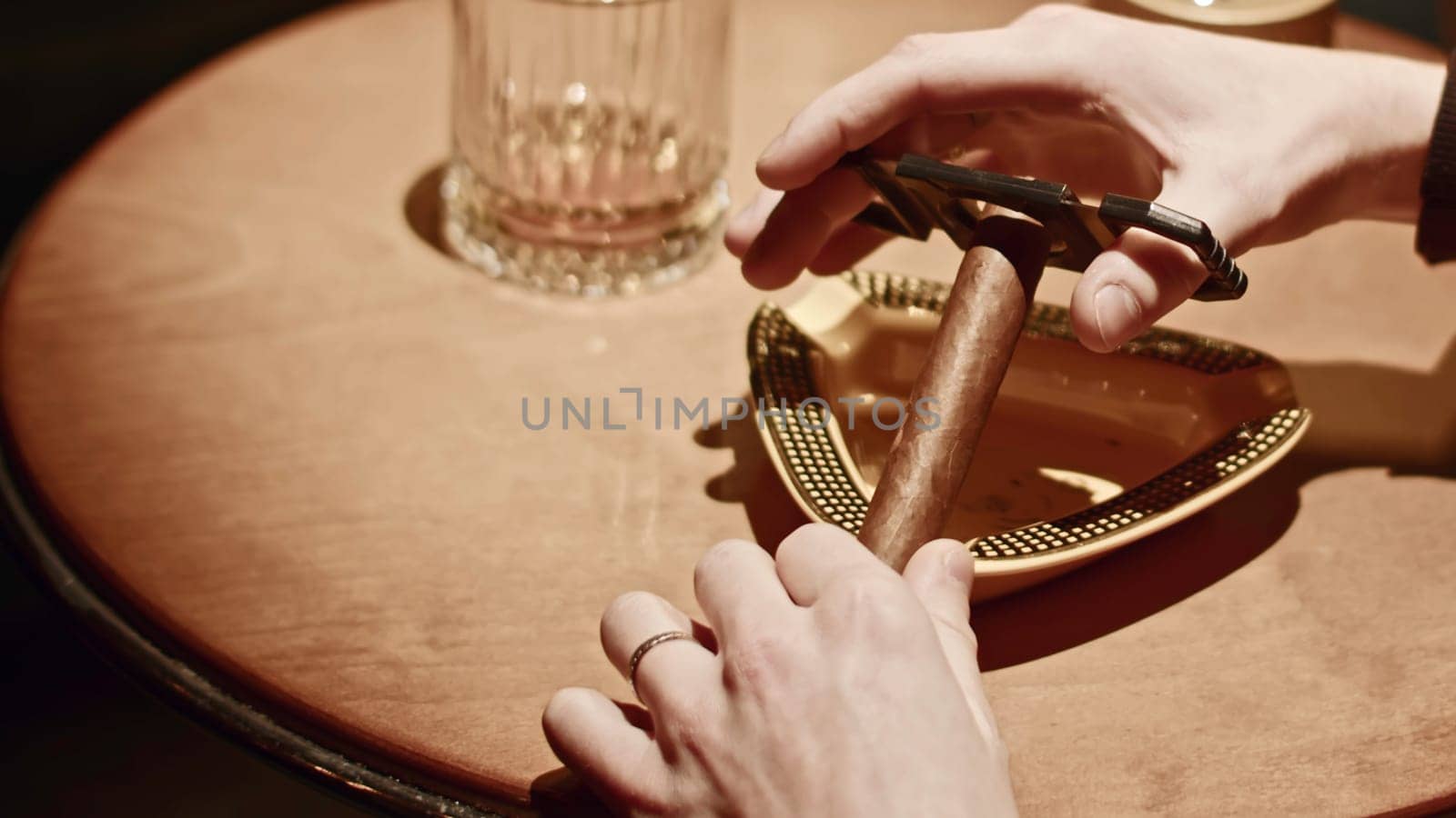 Close-up of man cutting cigar. Media. Man cuts off edge of Viagra for smoking. Professional cigar cutting knife in Cuban club.