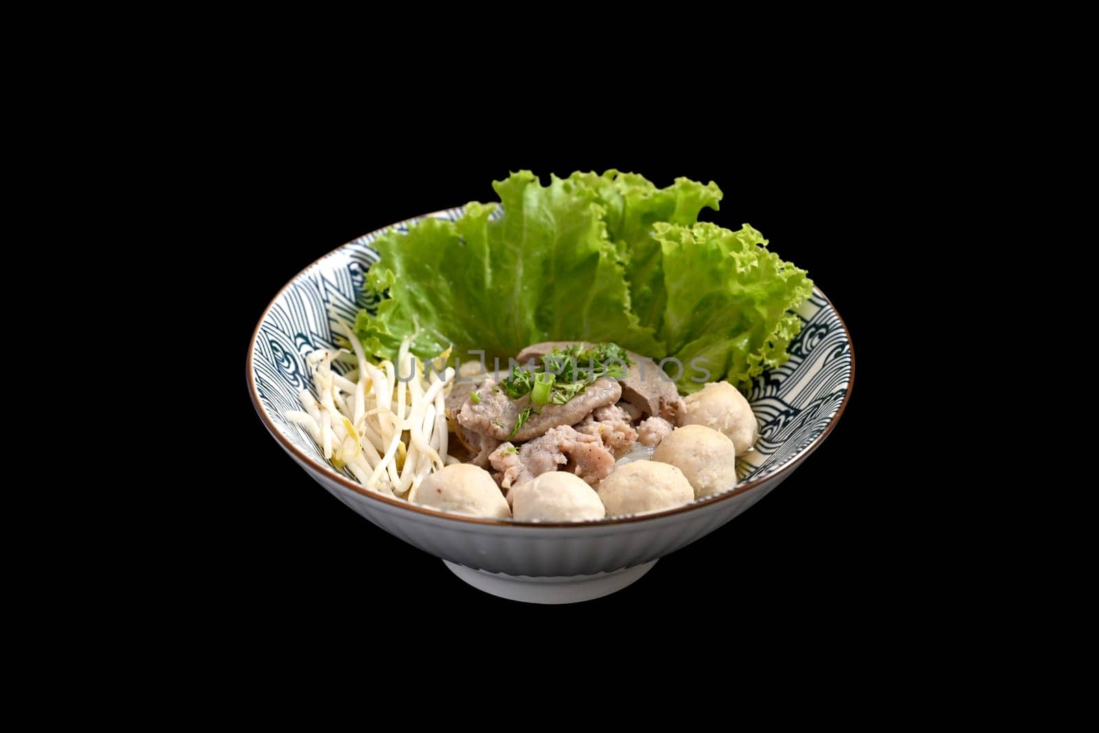 Thai noodles soup with boiled pork offal and vegetables serve in bowl on black background. Asian food concept.
