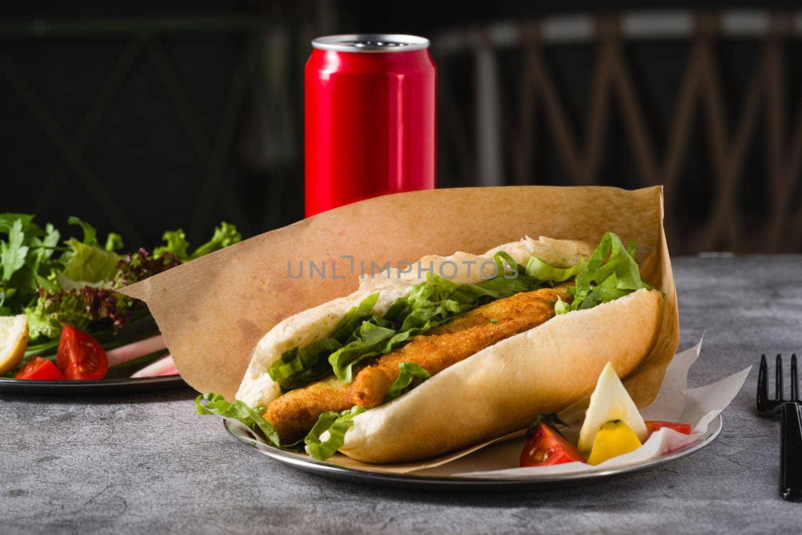 Fried fish sandwich with greens on the stone table. Turkish name Balik Ekmek