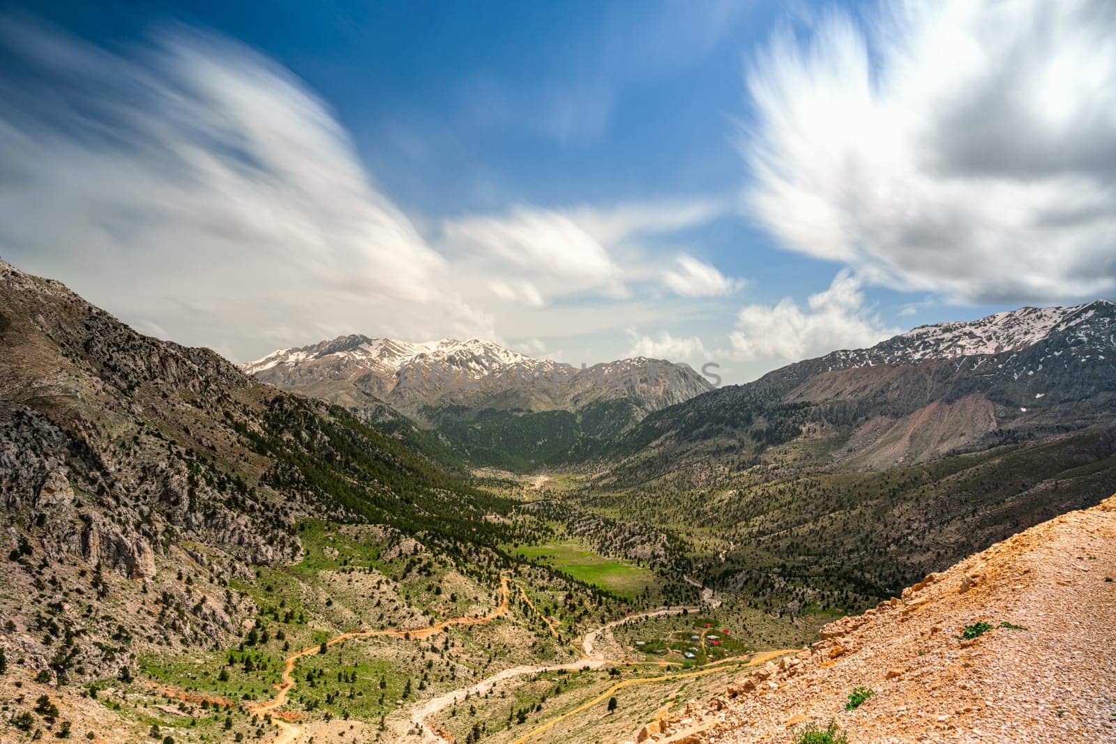 The lush green Sobucimen plateau in spring and the mountains with some melted snow behind.