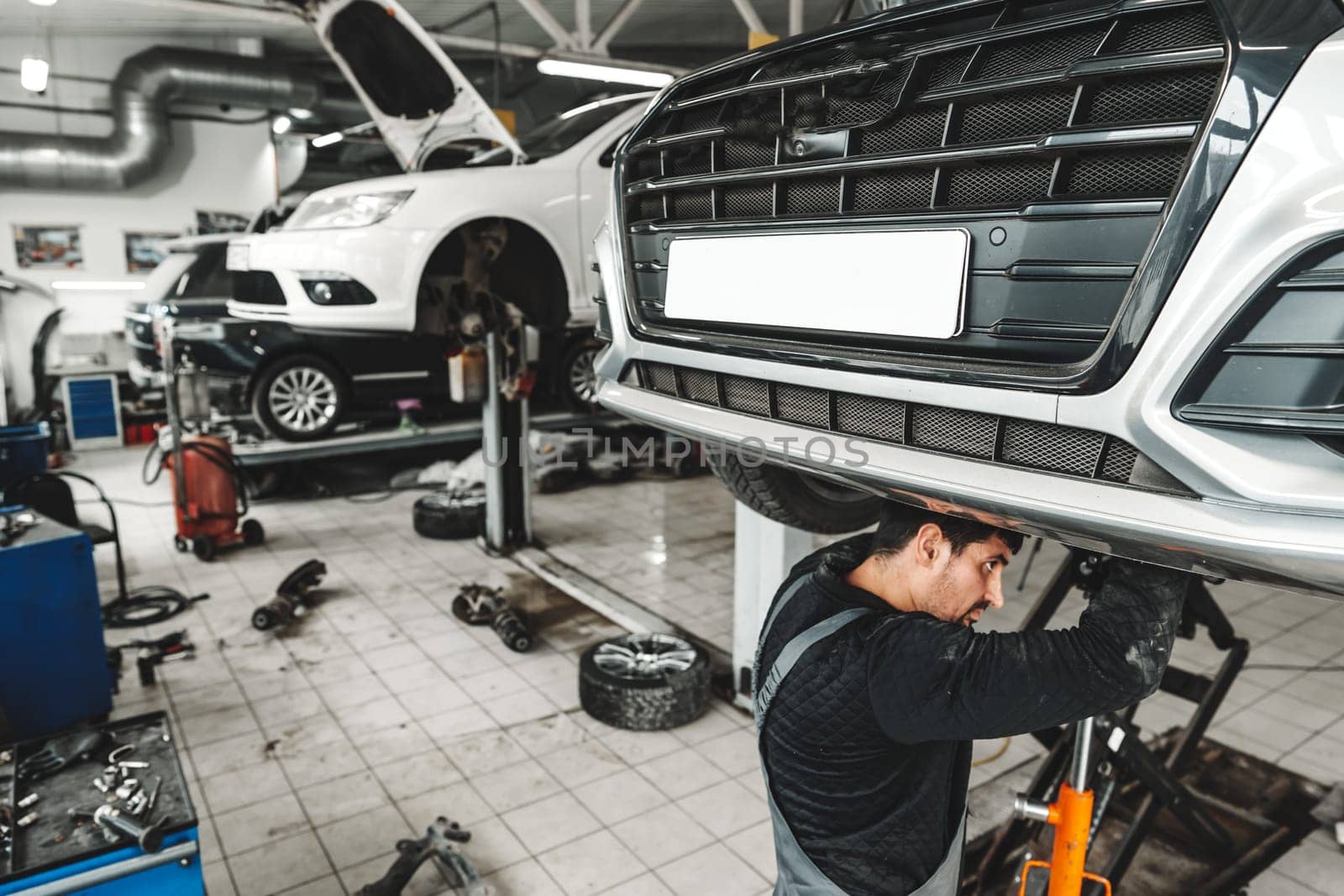 Auto mechanic repairs running gear of a car in car service close up