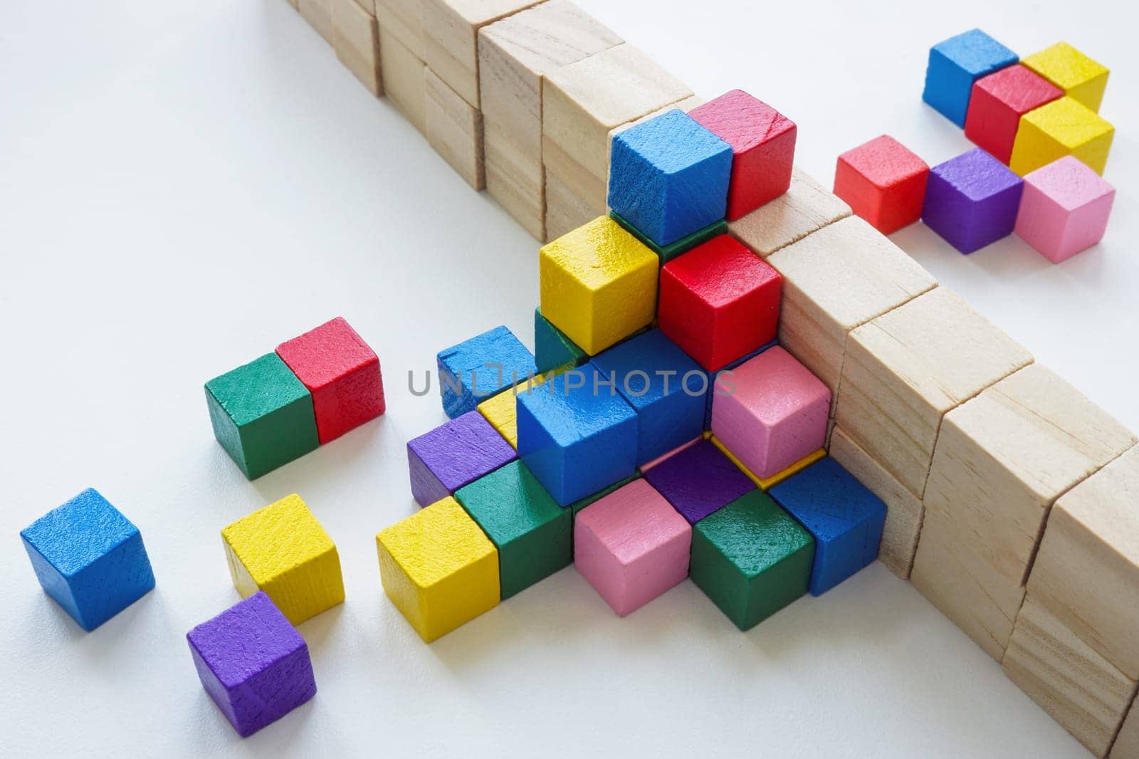 Colored cubes overcome an obstacle in the form of wall. Creativity or diversity and inclusion concept.