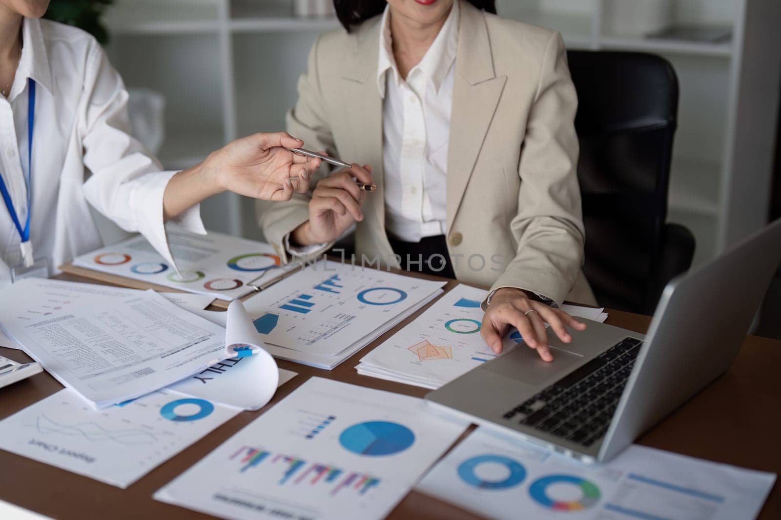 Businesswomen analyzing data charts in office. Concept of teamwork and data analysis.