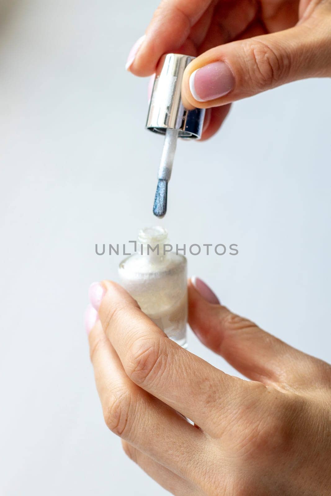 Shot of the beautiful woman's hand holding bottle of nail enamel