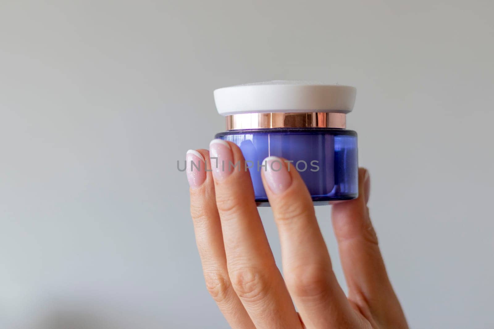 Shot of the beautiful woman's hand holding bottle of skin care product.