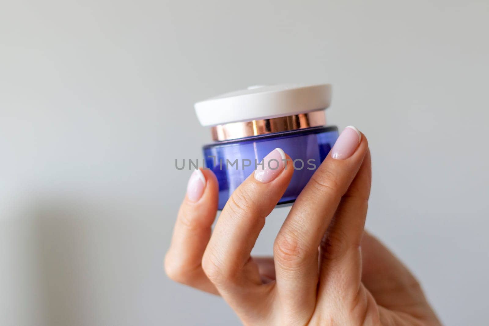 Shot of the beautiful woman's hand holding bottle of skin care product.