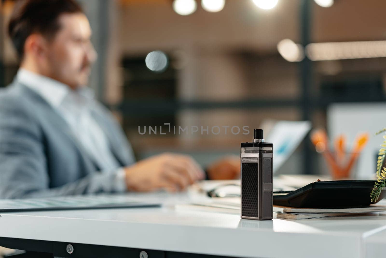 Vape on the working table of a male businessman close up