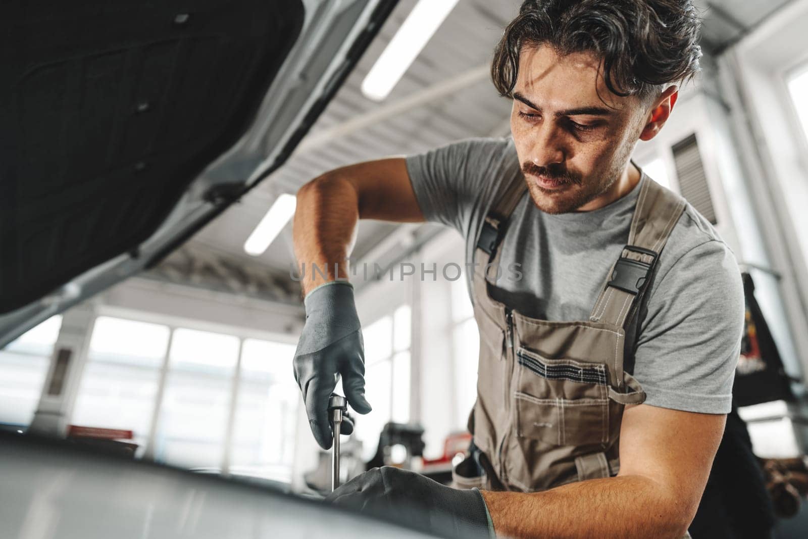 Mechanic examining car in auto car repair service center close up