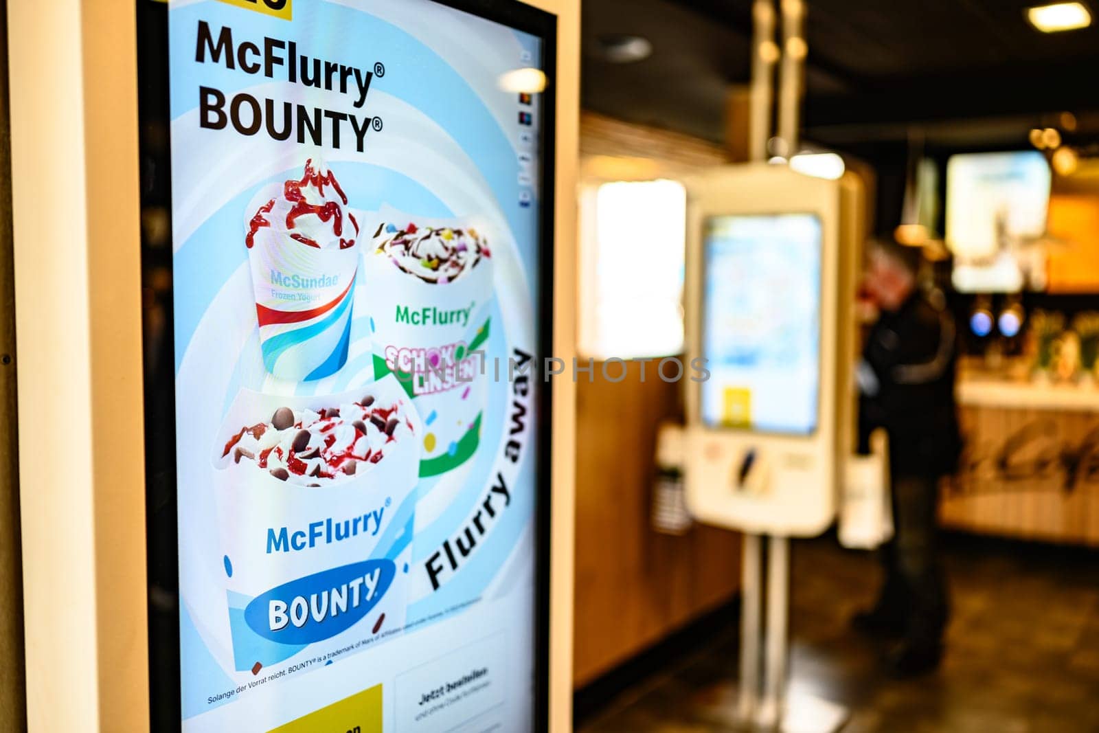 Berlin, Germany - 10 April 2023: self-order counter with advertising inside of restaurant McDonald's