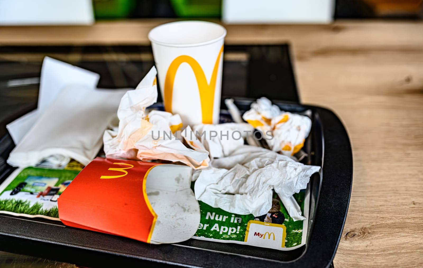 Berlin, Germany - 10 April 2023: trash after food on a tray on a table inside the restaurant McDonald's