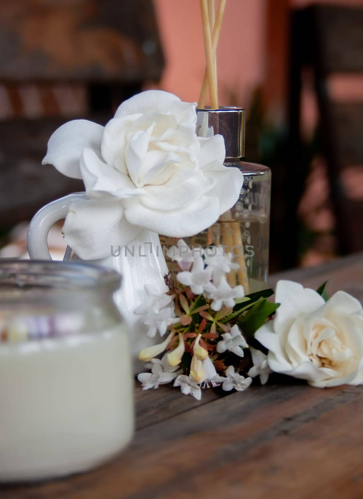 Candle and natural white flowers on a rustic table. Spa concept by VeroDibe