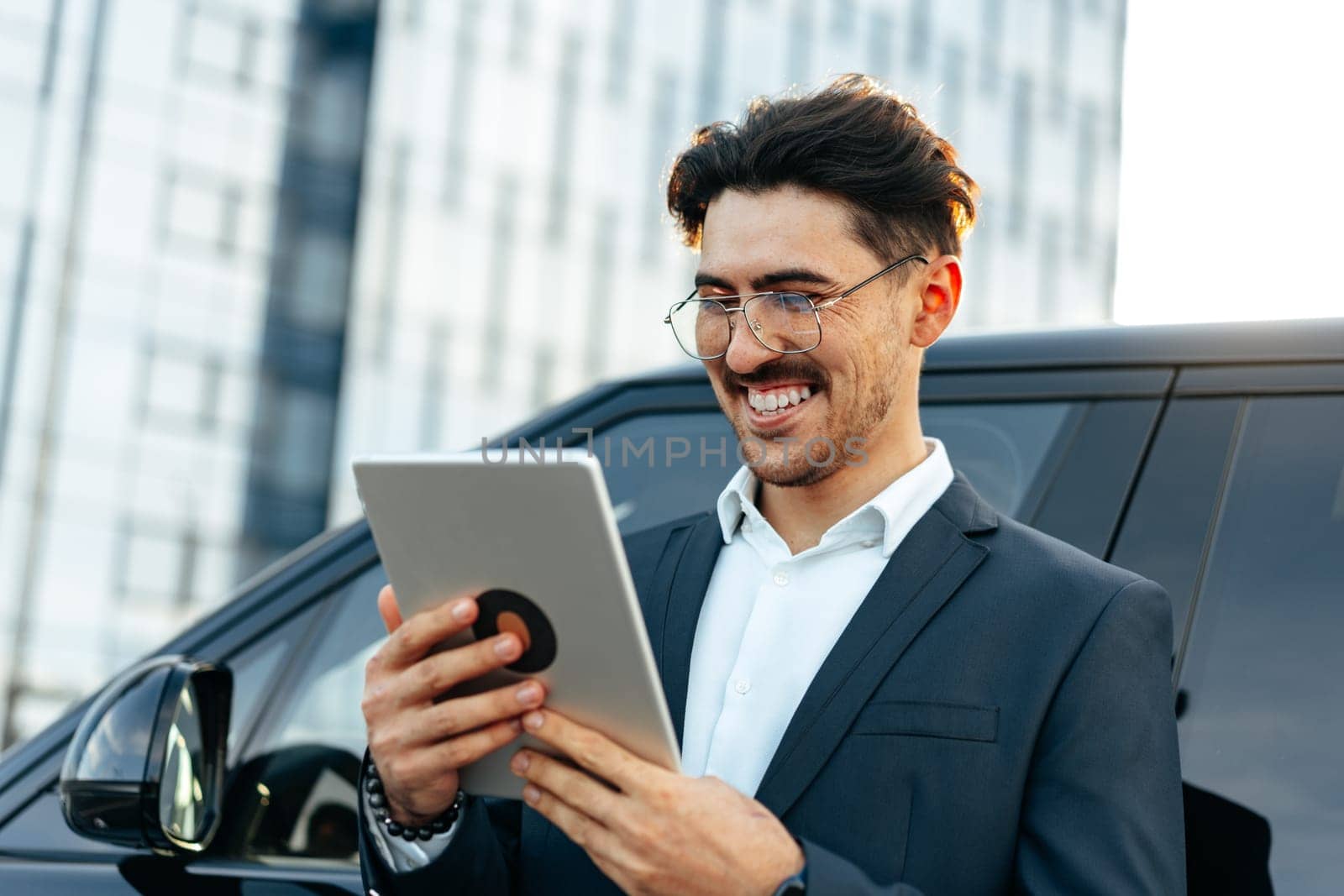 Young businessman using digital tablet while standing outdoors close up