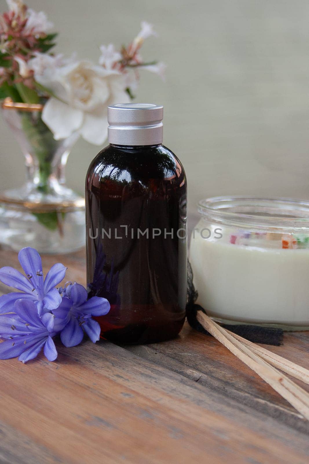 Fragrance diffuser on rustic table decorated with natural light blue flowers by VeroDibe