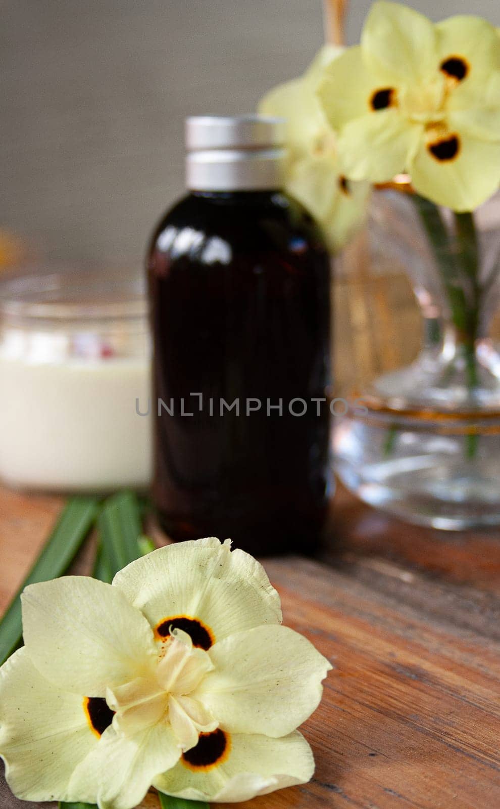 Close-up african iris flower with spa set on rustic table. Sap concept. Vertical by VeroDibe