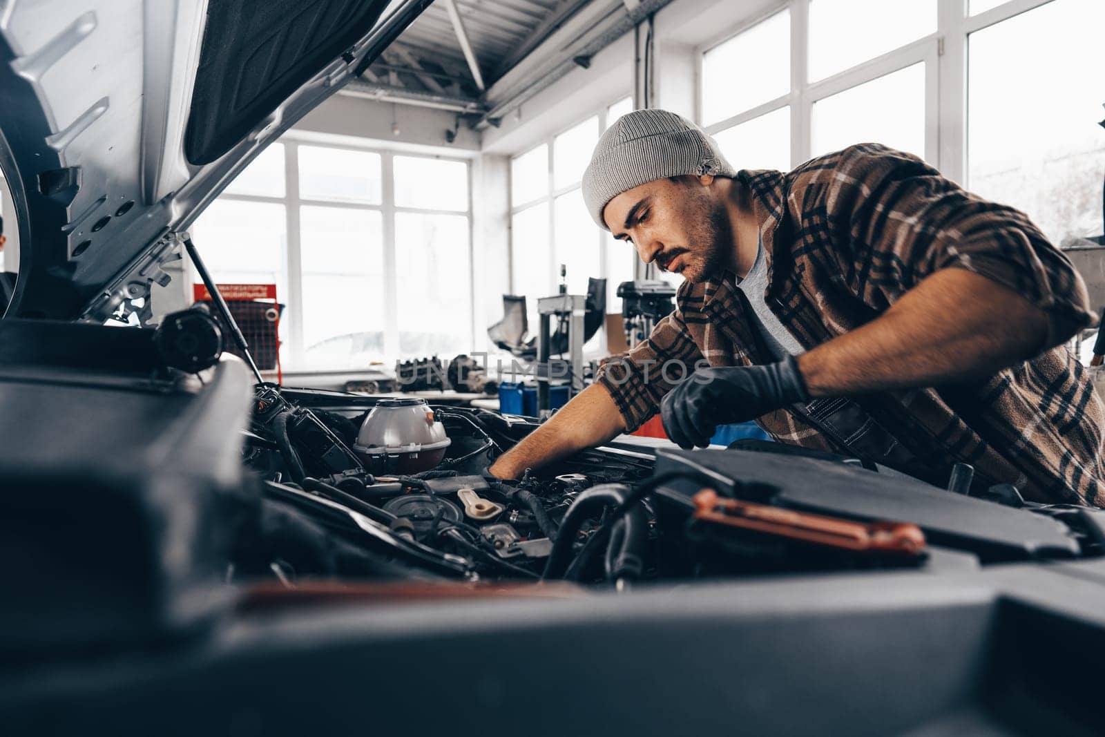 Mechanic examining car in auto car repair service center close up